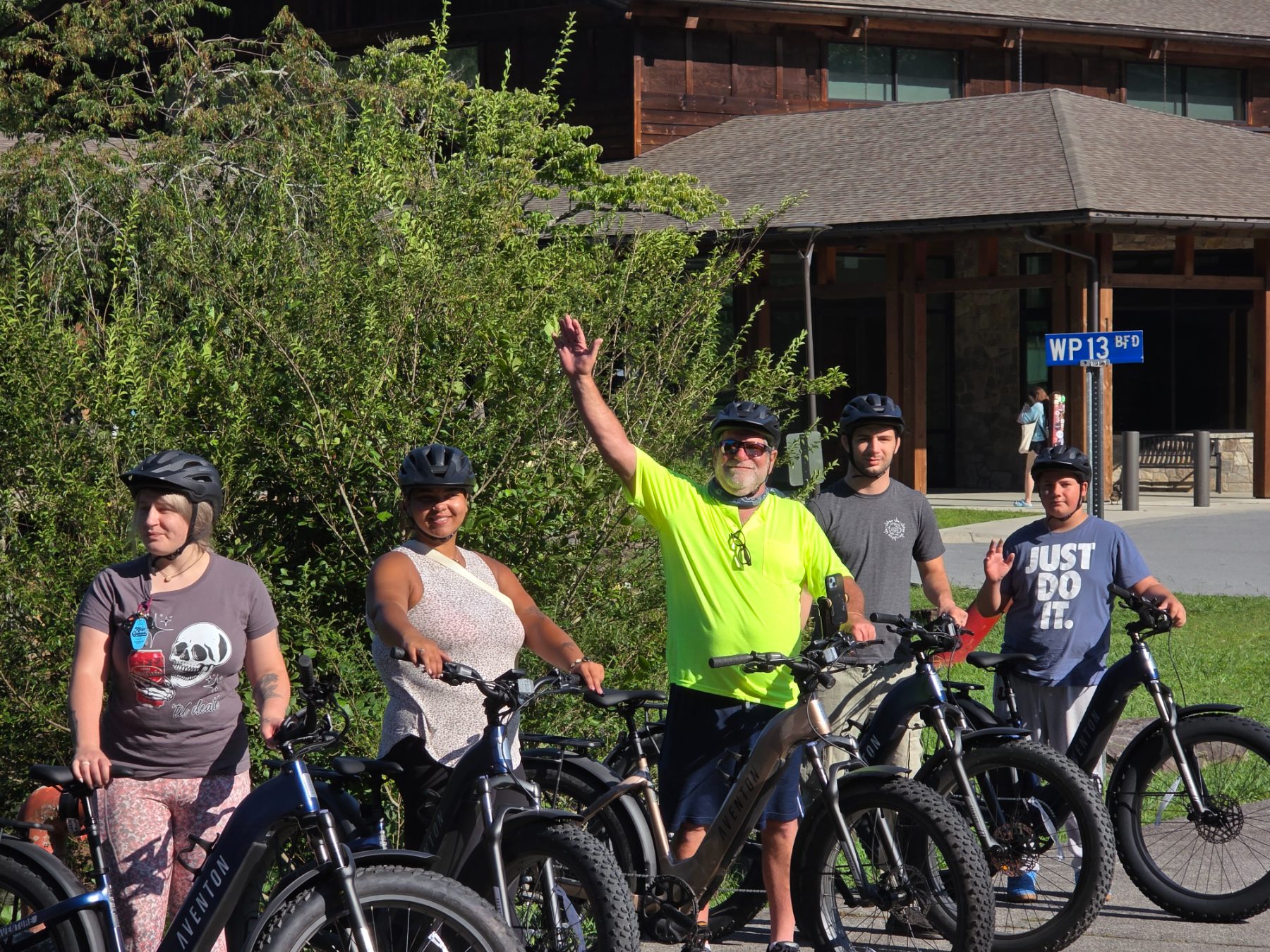 Helmeted guests lined up with the fleet of Aventon fat-tire e-bikes before a morning ride