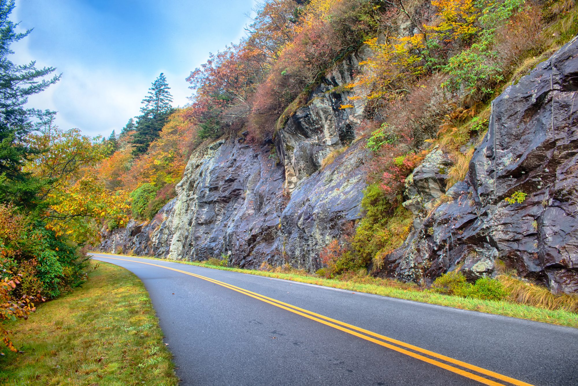 The road was cut through solid rock in places; the blasted face is still visible.