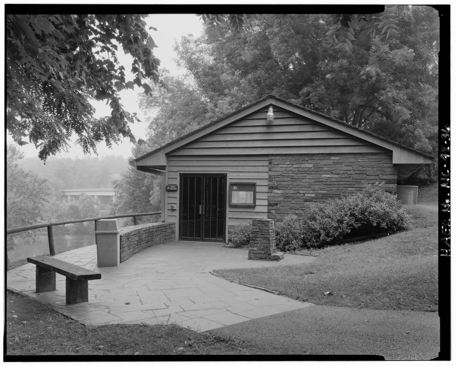 James River, VA. A long low footbridge over a wide river; a stone-walled canal lock chamber.