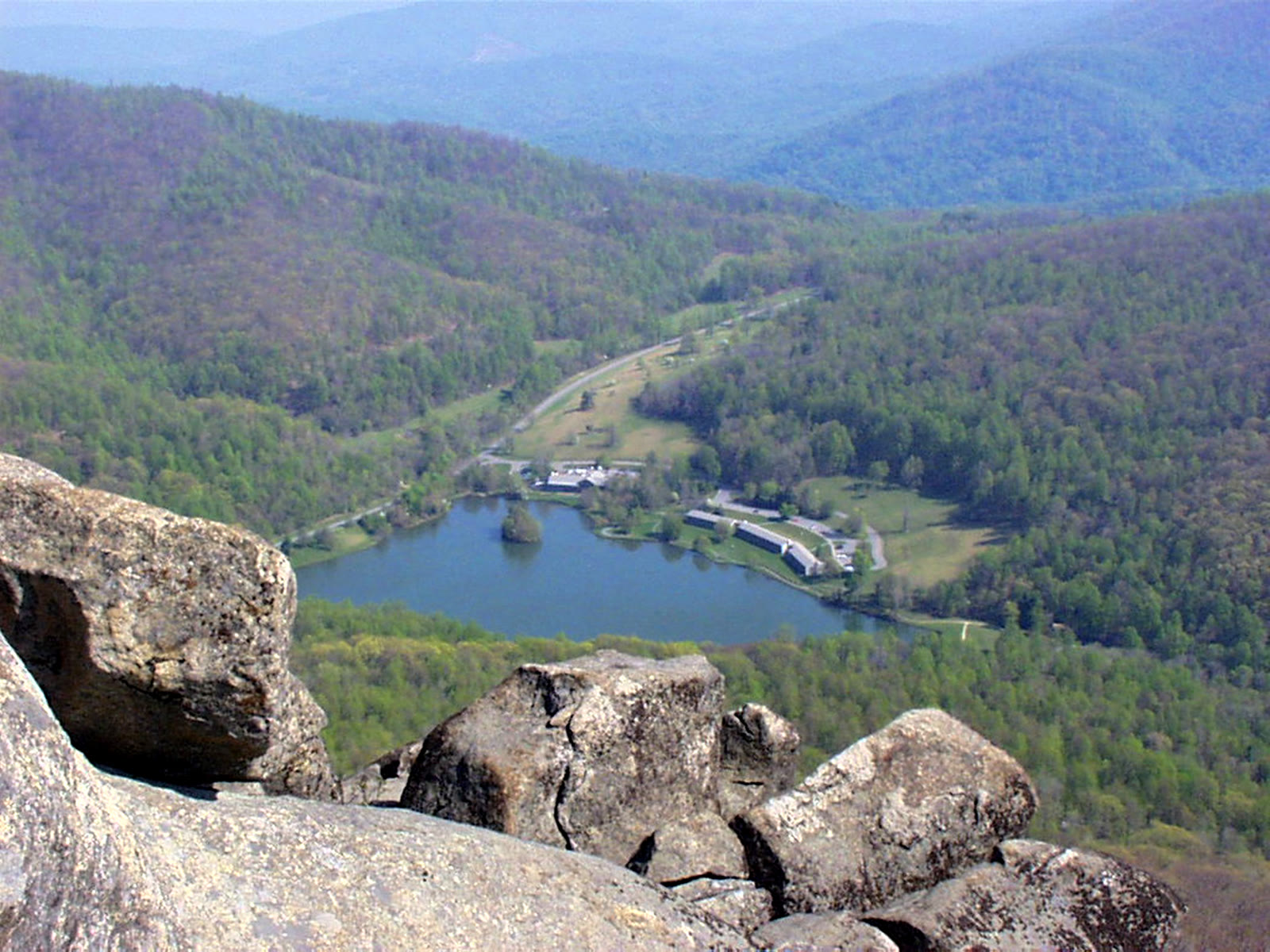 Peaks of Otter, VA. The pointed cone of Sharp Top mirrored in Abbott Lake with the low white lodge on the far shore.