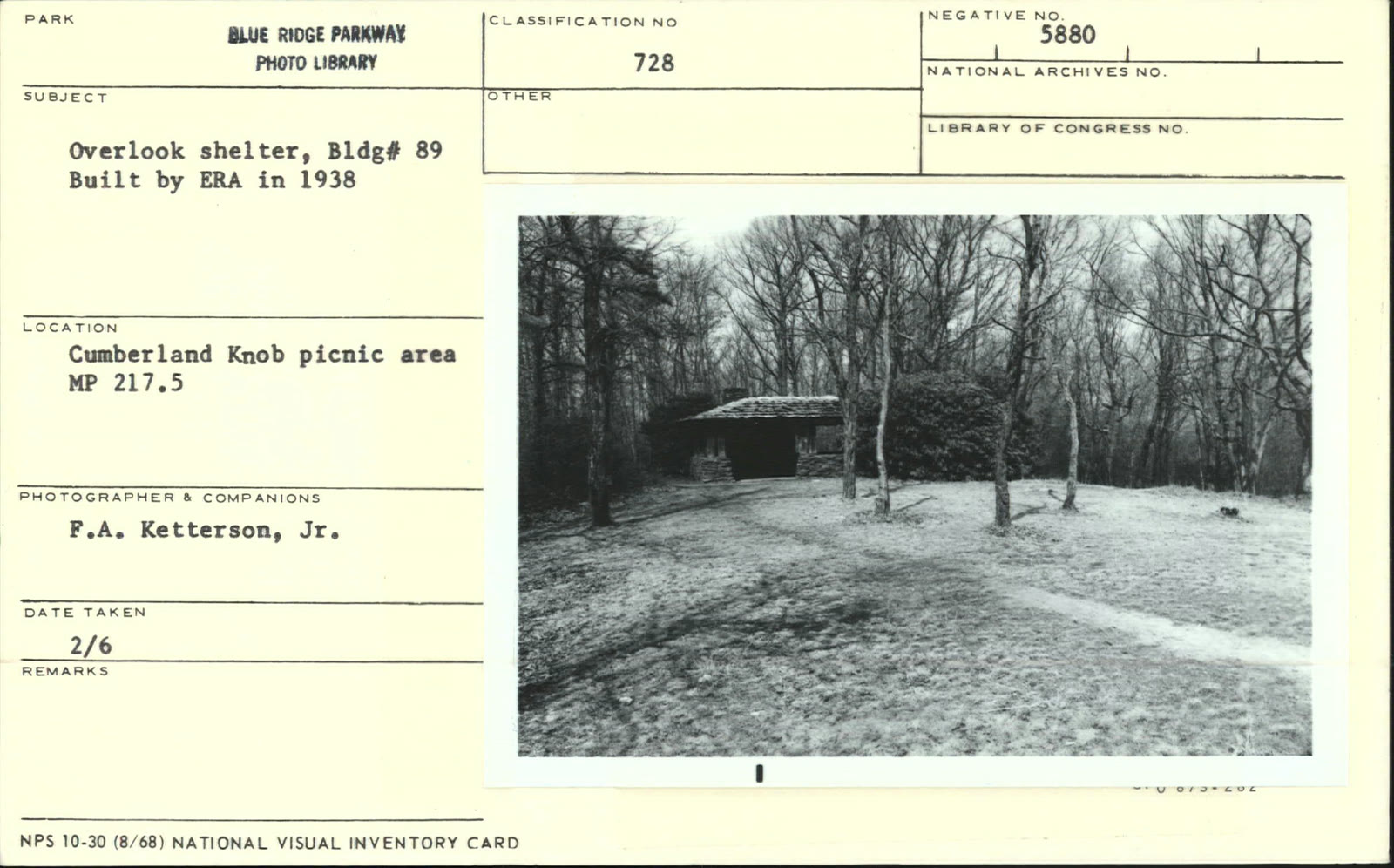 Cumberland Knob, NC. A stone overlook shelter standing in an open mown meadow ringed by hardwoods.