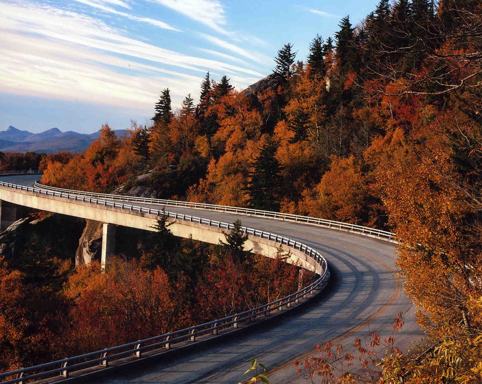 Linn Cove Viaduct, NC. The viaduct's long S-curve wrapping a boulder-strewn mountain shoulder, seen from above and to the side.