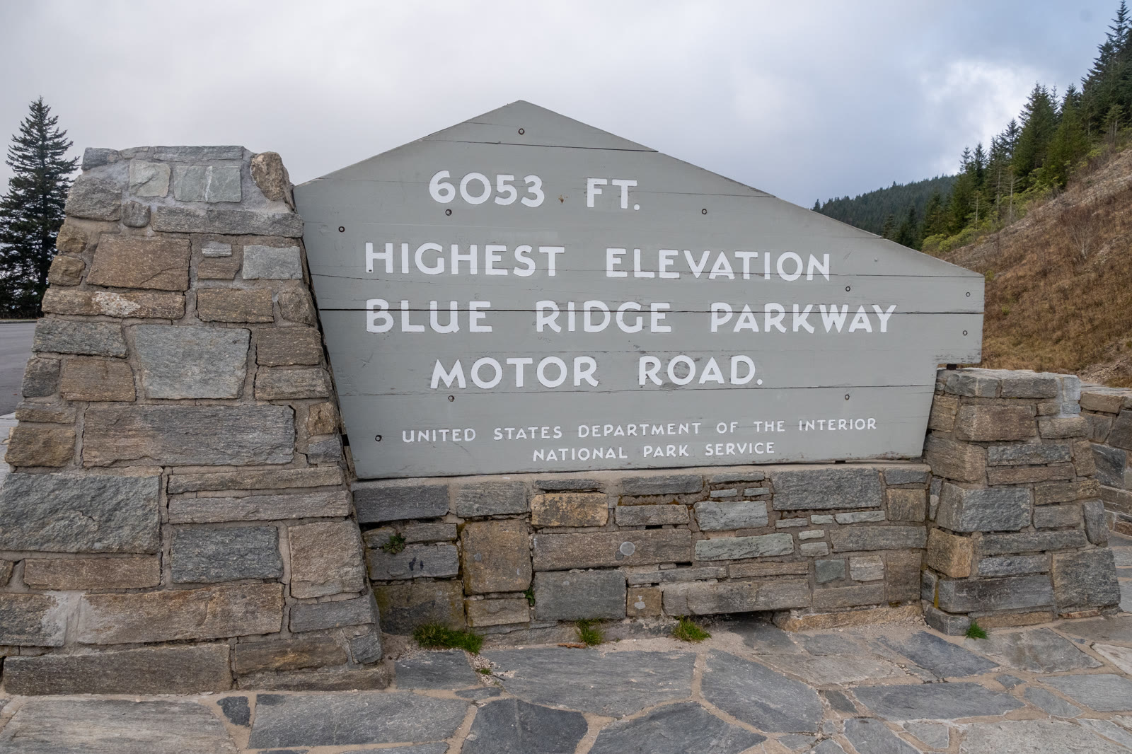 Richland Balsam Overlook, NC. The wooden Parkway sign reading the elevation and Highest Point, dark spruce-fir behind it.
