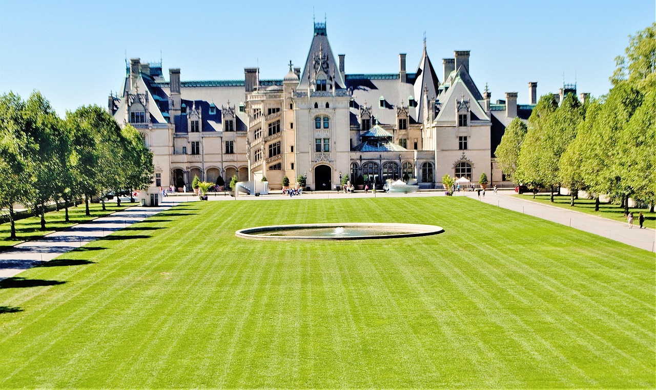 Biltmore House seen across the front lawn, with the reflecting pool and the tree-lined esplanade leading up to the facade